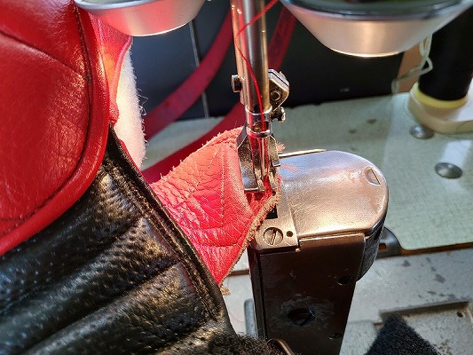 レーシングブーツの破損パーツをミシンで縫い直しているところ